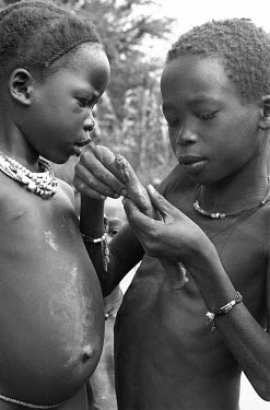 Anuak children play with a clay doll.