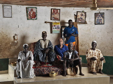Paramount Gonja chief Kusugu-Wura Kunkara I with his son (and most likely successor), courtiers and photographer Jan Banning.  The Sweating Subject is a small series of portraits of tribal chiefs in t...