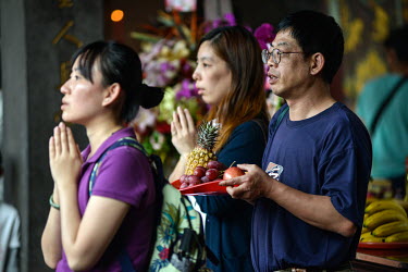 Worshippers with offerings prey at the historic Bao'An Temple. The temple was constructed in 1742 and inducted into UNESCO for cultural heritage conservation in 2003.