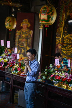 A man praying at the historic Bao'An Temple. The temple was constructed in 1742 and inducted into UNESCO for cultural heritage conservation in 2003.