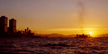 One of the Jordan Road vehicle-carrying ferries crossing Victoria Harbour from HK Island (the Macau Ferry Terminal towers are seen at far left) towards Kowloon, at sunset.