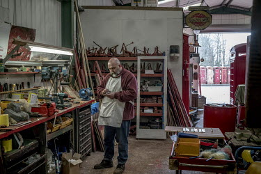 Tony Inglis in a workshop at Unicorn Restorations, a company that renovates and sells disused street furniture especially the iconic Post Office red telephone kiosks.