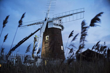 A worker on a cherry picker working on the sails of the National Trust's Horsey Drainage Windpump as a three year restoration project reached its final stages on the Norfolk Broads. The building has h...