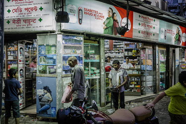Customers at a pharmacy on the corner of Dr. Martin Luther King Sarani (formerly Wood Street) and Short Street as it opens early in morning.
