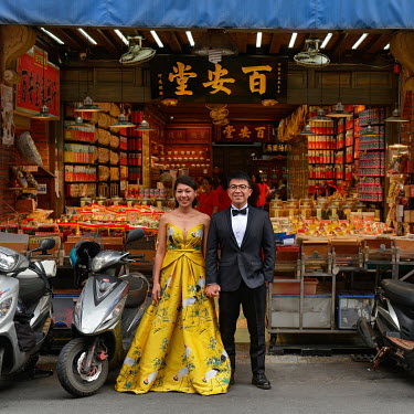 A couple pose for their pre-wedding photos outside a traditional provisions store on Dihua Street. One of the oldest trading streets in Taipei, Dihua St. dates back to the 1850's and has been an impor...