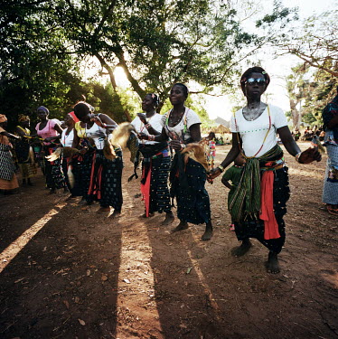 A group of women dance during the funeral celebration of an elderly woman from the village.