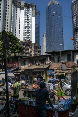 Traffic, food stalls and old low rise buildings are all dwarfed by the gleaming high rise skyscrapers that are rapidly being built all across the city.