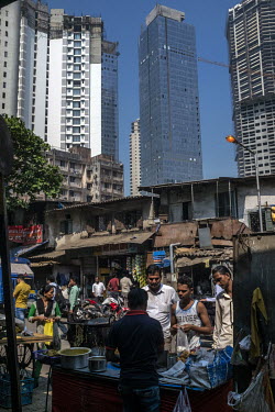 Traffic, food stalls and old low rise buildings are all dwarfed by the gleaming high rise skyscrapers that are rapidly being built all across the city.