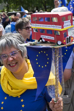 A woman carries a homemade card London bus, in reference to the Leave campaign's referendum advertisements, during a pro-EU, anti-Brexit march in central London.