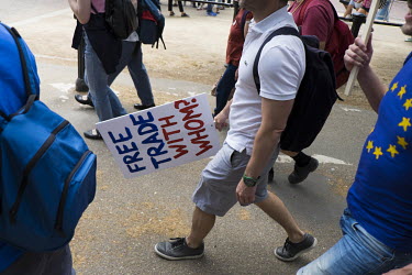 A man carries a placard with the slogan: 'Free trade, with Whom?' at a pro-EU, anti-Brexit march in central London.