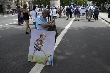 A man with a painting depicting Theresa May and Jeremy Corbyn at a pro-EU, anti-Brexit march in central London.