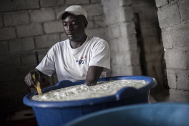 A worker at Vincent Kanyamahanga's cheese-making dairy farm in Katale stir through fresh milk as it starts to solidify during the process of cheese making.