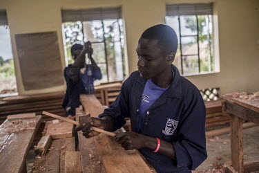 Refugees and members of the local community work together in a carpentry workshop at a techincal college in Yumbe.