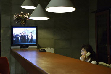 A television broadcasts footage of Kim Jong-un at the Yanggakdo International Hotel's bar.