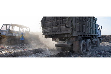 A truck dumps waste at a rubbish dump near Denpasar.