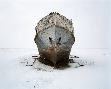 A fishing boat stands stranded in the snow. The towns of Aralsk and Tastubek used to support an industrial fishing fleet but the disappearance of the Aral Sea destroyed most of the industry.