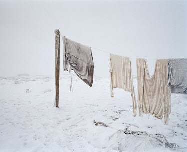 Washing hangs out on the washing line, covered in frost, in the village of Tastubek near the Aral Sea.