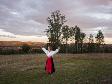 Tove Strander wearing traditional dress, on a meadow near her step-mother's house in Ullvi. She is visiting from Stockholm, where she lives, for the midsummer celebrations in the village. This part of...