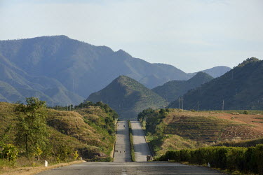 The mountainous backdrop to a road that leads to Pyongyang on which there are more often pedestrians and cyclists than motorists.