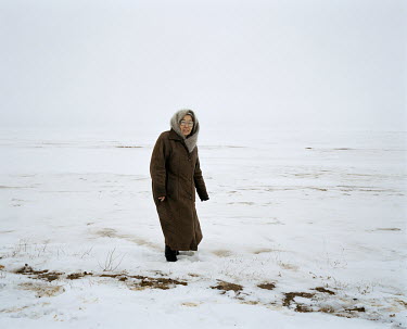 A woman walks across the frozen steppe between Aralsk & Tastubek.
