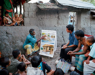 Manan Mullah (70) gives a talk to his fellow villagers explaining the dangers of climate change and rising water levels.