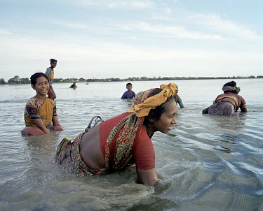 Women washing in the waters that surround their village.