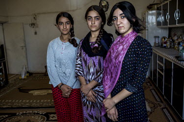 Three sisters standing in the living room of their house in Grdachal Refugee Camp where they were born.