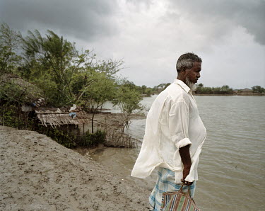 Manan Mullah (70) looks over the waters that surround his village.
