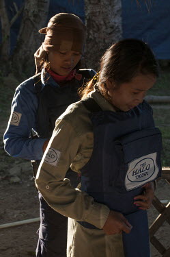 HALO trust team member Srey Yen helps Sophal into her protective vest before going into a minefield on the Thai-Cambodian border.