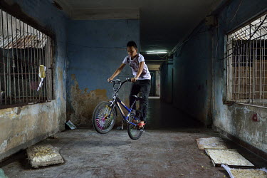 A boy performs tricks on a BMX bike in a corridor in the former Le President Hotel which was used by the American military in the 1960s up until the evacuation of 1975. Many of the rooms in the dilapi...