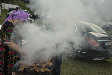 A woman barbeques meat at a Roma festival celebrating the Birth of the Virgin Mary (Assumption Day). Since the fall of the communist regime this annual event has been the biggest gathering of the Roma...