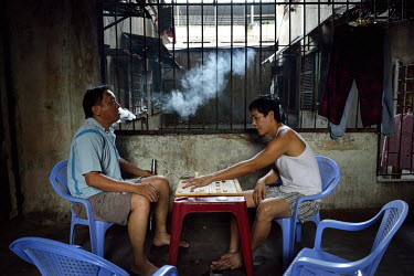 Two friends play Xiangqi, a Chinese game, and smoke a water pipe in a corridor at the former Le President Hotel on Tran Hung Dao Street. It was used by the American military during the 1960s up until...