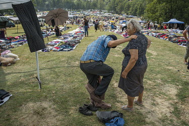 A man tries on a pair of second hand trousers at a stall selling items for between one and five Euros at a flee market attached to a Roma festival celebrating the Birth of the Virgin Mary (Assumption...