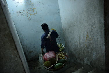 A woman selling vegetables carries her products through the former Le President Hotel offering them to the few families still living in the building. The hotel was used by the American military in the...