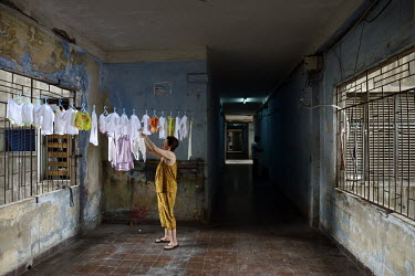 A woman hangs out washing in the former Le President Hotel which was used by the American military in the 1960s up until the evacuation of 1975. Many of the rooms in the dilapidated building were then...