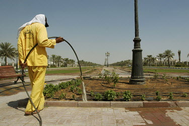 A worker waters plants at the entrance of The American University of Sharjah.