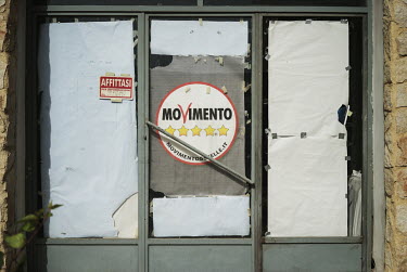 A poster for the Five Star (Movimento Cinque Stelle) political party shows in the window of a premises available for rent.