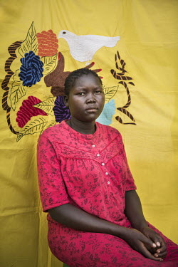 Loice Igo in front of her Milaya (a traditional hand-decorated sheet) in the Bidibidi refugee settlement. She came to Uganda on her own and is now staying with her foster mother Rona. Loice is only 17...
