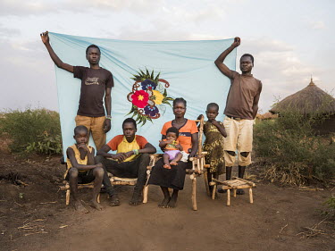 Mary Tabu and members of her family in front of her Milaya (a traditional hand-decorated sheet) in the Bidibidi refugee settlement. "I live here with my four children and my three brothers. They recen...