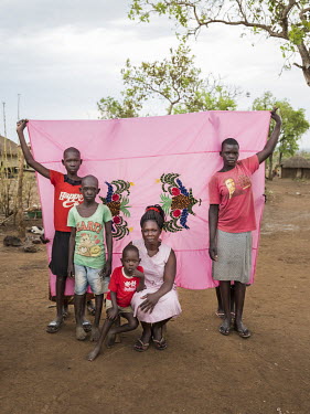 Helda Fatuma (28) and her children standing in front of her Milaya (a traditional hand-decorated sheet) in the Bidibidi refugee settlement. "When the fighting in South Sudan started we heard gunshots...