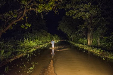 John Kaswabuli, a driver who works for NGOs transporting people to and from the various refugee camps in the region, checks the depth of the water on the road to Omugo refugee camp.