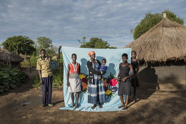 Rose Jaun (38) in front of her Milaya (a traditional hand-decorated sheet) in the Bidibidi refugee settlement. L-R: Moses Taban (28), Ferida Aate (13), Rose Jaun (38), Kenneth Tereka (1), Rose Gaba (1...
