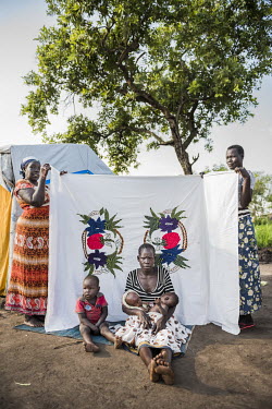 Lily Yeno (23) in front of her Milaya (a traditional hand-decorated sheet) in the Bidibidi refugee settlement. She gave birth to her twins Francis Yonga and Festo Goya in Bidibidi in June 2017. Holdin...