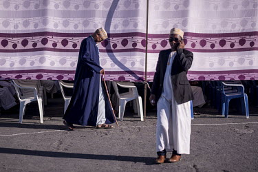 A wedding guest makes a call outside a large marquee during the 'Madjiliss', one of several events during a traditional two week wedding.