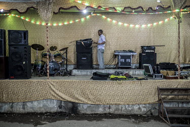 A technician sets up the sound system ahead of a wedding's 'Hambarousi' event.