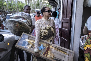 Members of the bride's family arrive with gifts, including a ceremonial sword, at the home of the groom on the day of 'Massingo' during the two week's of events for a wedding.