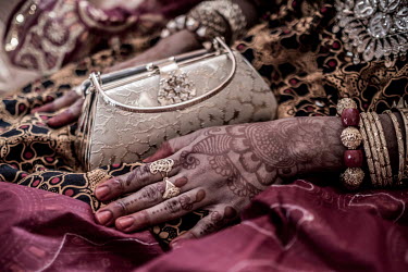 Henna tattoos decorate the hands of Badaant el Mounyrou, wearing full wedding attire, waits in the marital bedroom for the arrival of the groom.