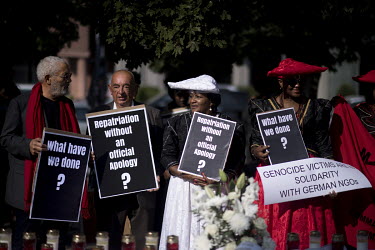 Protestors stand outside the Franzoesische Friedrichstadtkirche during a joint German and Namibian church and state ceremony where a Namibian delegation will receive the remains of Herero and Nama peo...