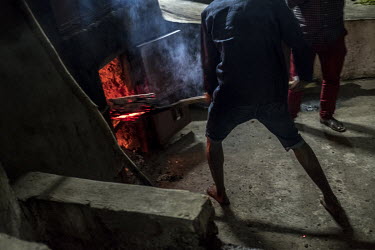 A worker stokes the wood-burning furnace at a ylang ylang distillery. The oil distilled from the ylang ylang flower is a key ingredient in luxury perfumes and some cosmetics as well as being popular f...