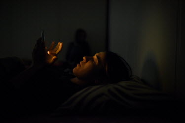 Nadia Murad, a 21 year old Yazidi woman, checks her mobile phone before going to sleep in her temporary home in a refugee camp.  In 2014 she was kidnapped from her home by Islamic State militants and...